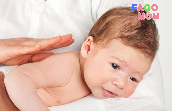 Khum tay vỗ nhẹ lưng bé giúp trẻ ho bật chất nôn còn lại trong họng ra ngoài